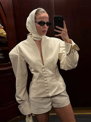Person wearing a white outfit with a deep neckline and button details, standing in front of a mirror.