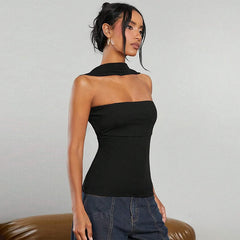 Woman wearing a black one-shoulder top against a plain background