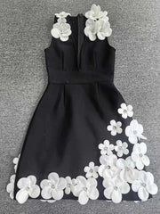 Black dress with white floral embellishments on a gray background
