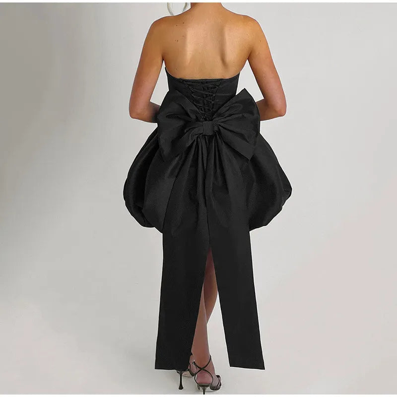 Black strapless gown with a large bow detail on a plain background