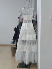 Back view of a white maxi dress with mesh and satin panels on a mannequin
