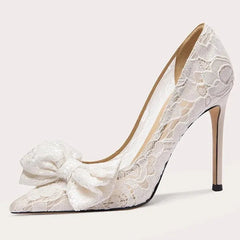 White lace high-heeled shoe with a bow on a light gray background