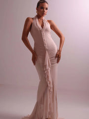 Woman wearing a beige evening gown against a plain background