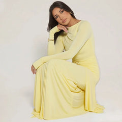 Woman in a yellow dress sitting on a white background