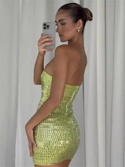 Woman in a strapless, sequined green dress taking a mirror selfie.