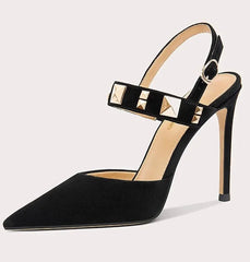 Black high-heeled shoe with studded detail on a light gray background