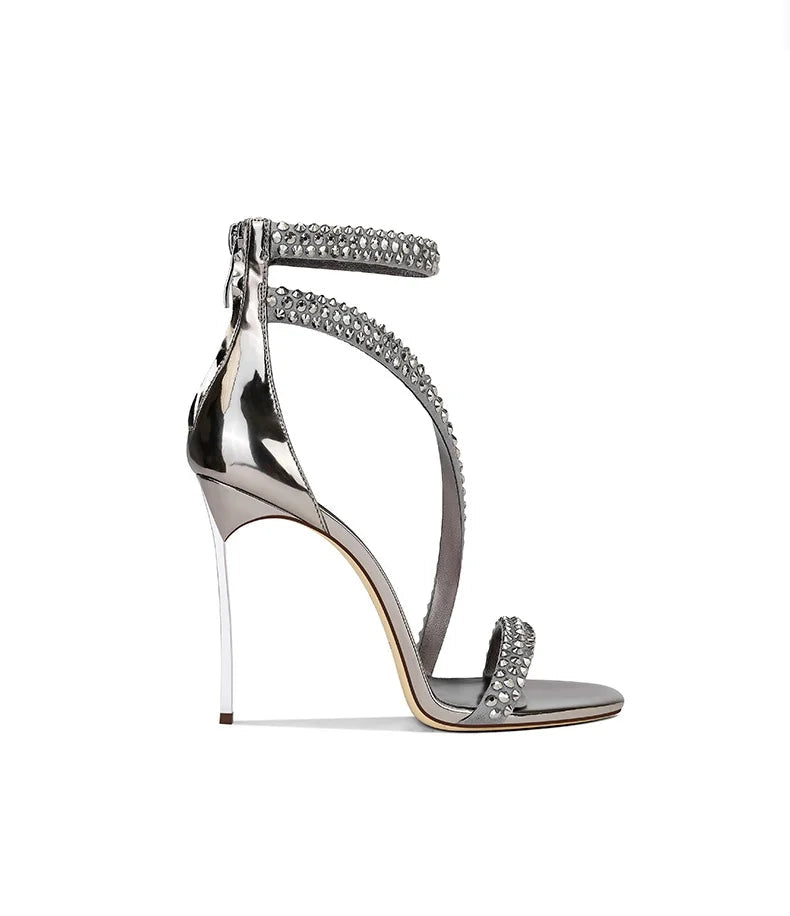 Silver high-heeled sandal with embellishments on a white background