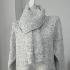 Gray knitted sweater on a mannequin against a plain background