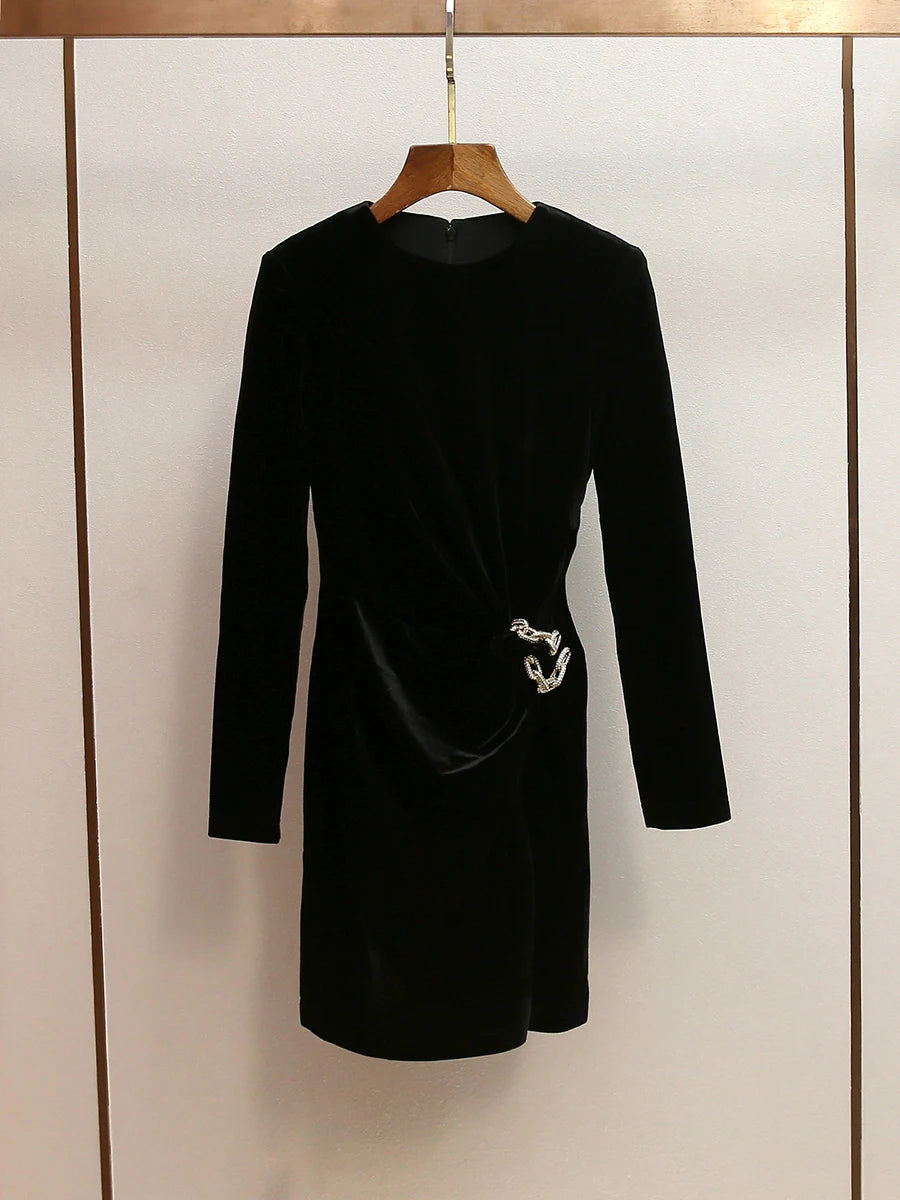 Black dress with a silver belt on a hanger against a neutral background