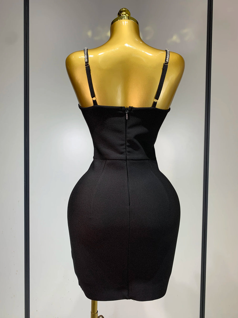 Black dress on a mannequin against a neutral background