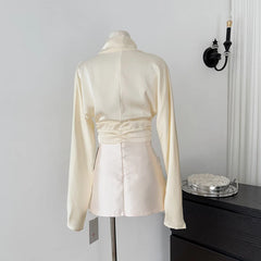 White satin jacket on a mannequin against a plain background