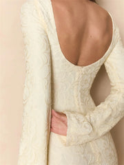 Close-up of a white lace garment with a cut-out design on a beige background
