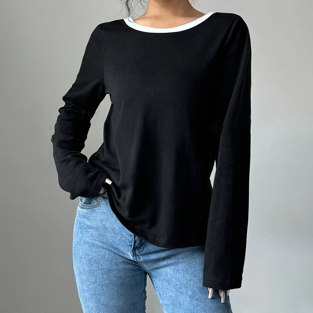 Person wearing a black long-sleeve top and blue jeans on a gray background