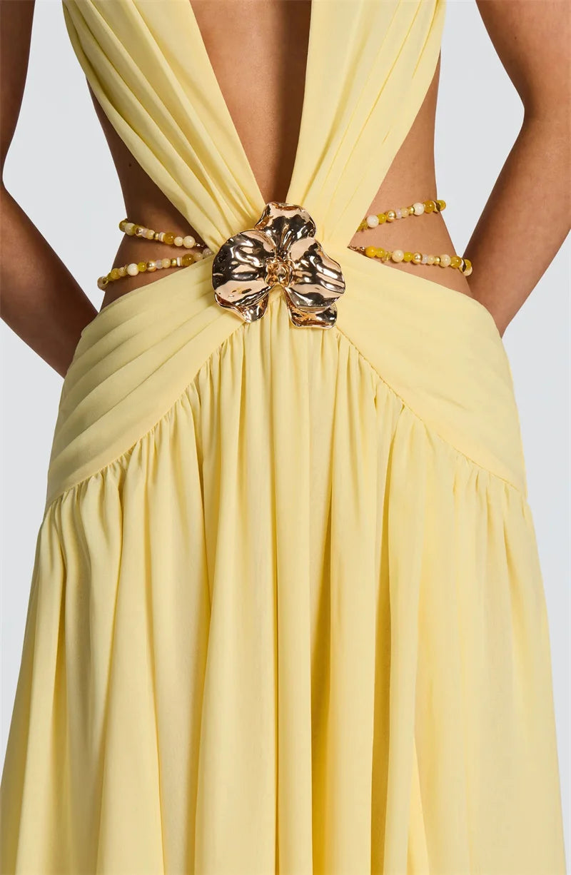 Yellow dress with gold embellishments on a plain background