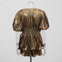Gold pleated dress on a mannequin against a white background