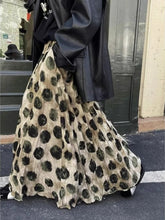 Person wearing a black coat holding a large leopard print bag on a street.