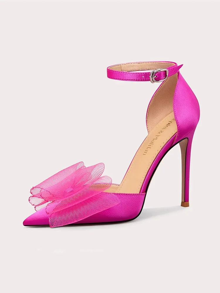 Pink high-heeled shoe with tulle details on a light gray background