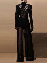 Black outfit with intricate back design on a neutral background