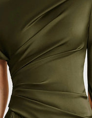 Close-up of a green dress with a draped design.