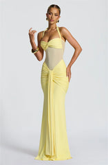 Woman wearing a yellow evening gown on a light gray background