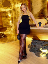 Woman in a black dress standing in a room with decorative elements.