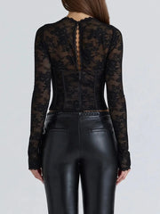 Person wearing a black lace top and black leather pants on a light gray background