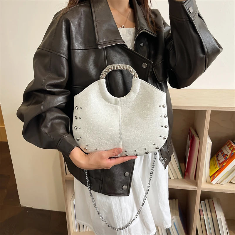 White studded faux leather hobo bag with metal hoop handle and chain strap.