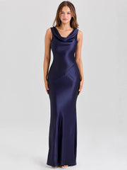 Woman wearing a navy blue evening gown on a light gray background