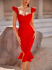 Woman wearing a red dress with ruffled shoulders in an outdoor setting.