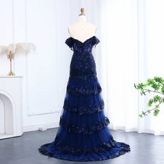 Navy blue evening gown on a mannequin against a white curtain background