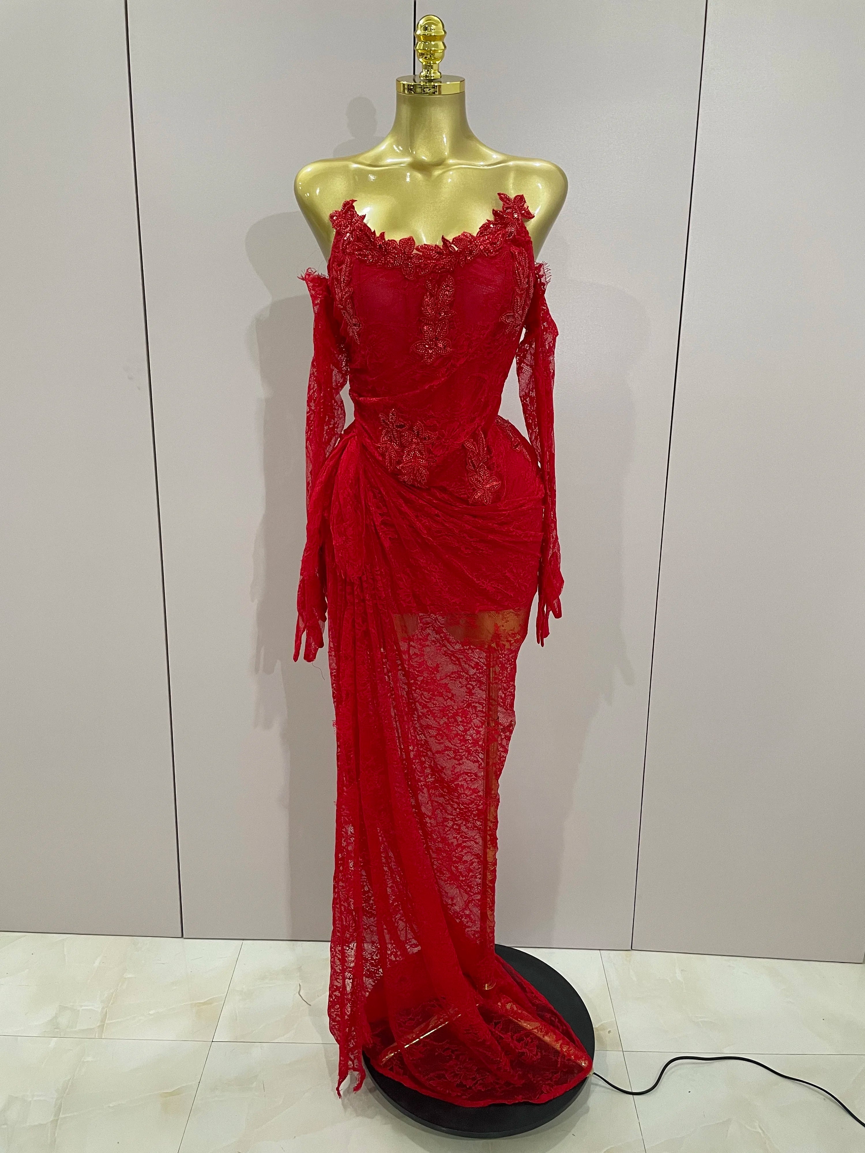 Red lace dress on a mannequin against a plain background