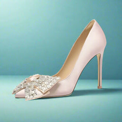 High-heeled shoe with decorative bow on a light gray background