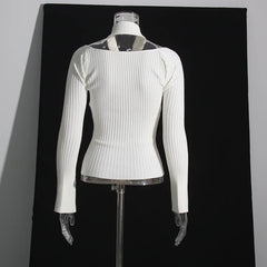 White ribbed sweater on a mannequin against a black background