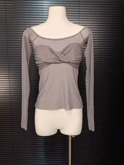 Gray long-sleeve top with a decorative front on a mannequin against a dark background