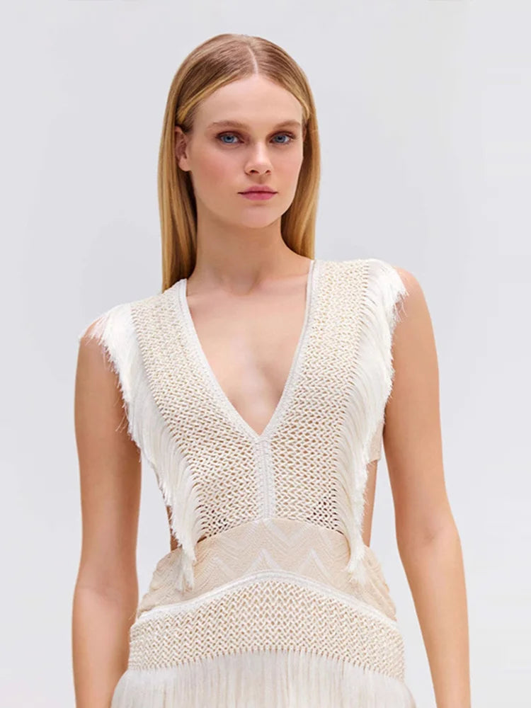 Woman wearing a white knit dress against a light gray background