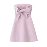 Pink dress with a large bow on a white background