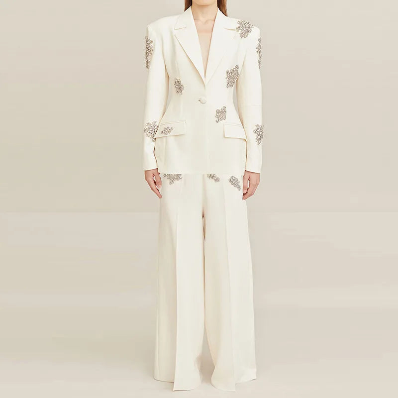 White suit with floral embellishments on a plain background