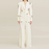 White suit with floral embellishments on a plain background