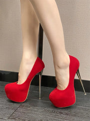 Red high-heeled shoes worn with beige tights on a neutral background