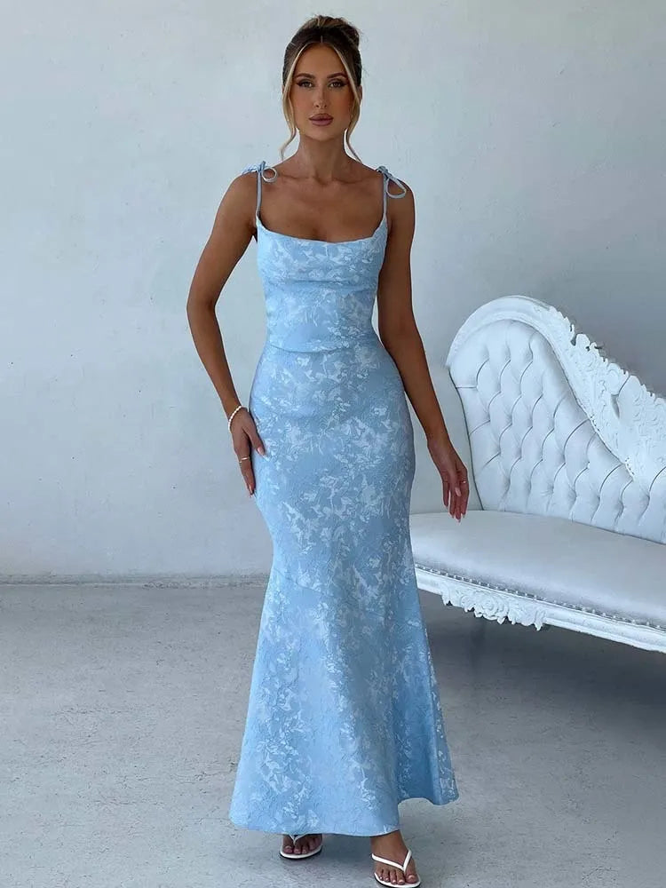 Woman wearing a light blue lace dress in a room with a white couch.