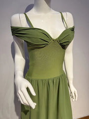 Green dress on a mannequin against a plain background