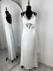 White satin nightgown with lace details on a mannequin against a white wall.