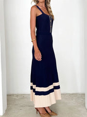 Woman wearing a navy blue and beige dress against a white background