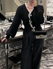 Person wearing a black outfit with lace details in an elegant interior setting.