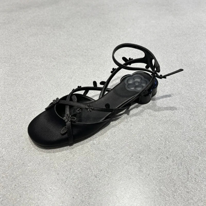 Close-up of black silk floral kitten heel sandal detail