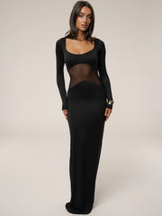 Black dress with sheer panels worn by a model on a plain background