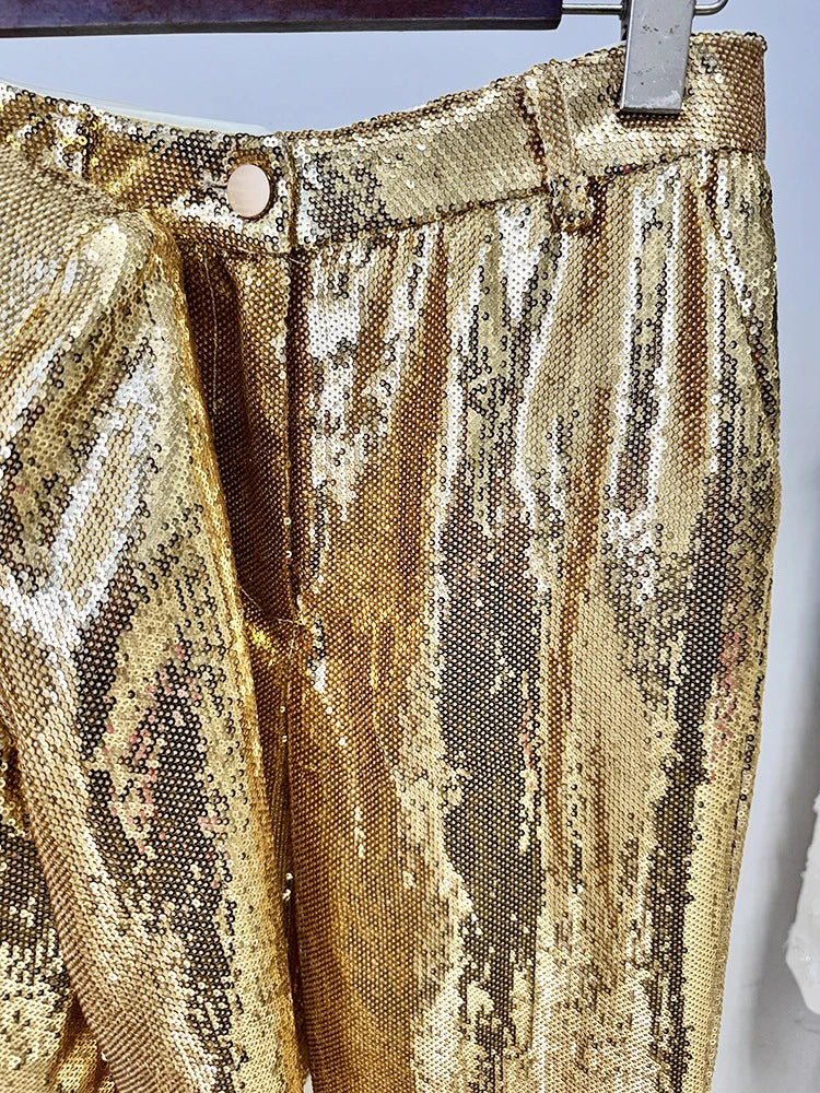 Gold sequin fabric on a hanger against a light blue background
