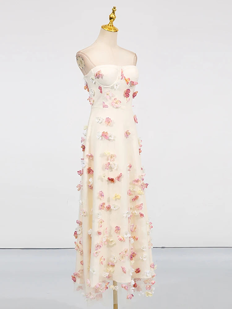 White dress with floral embellishments on a mannequin against a white background