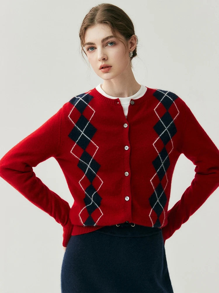 Person wearing a red argyle sweater with navy accents on a plain background