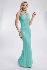Woman wearing a turquoise evening gown in a studio setting